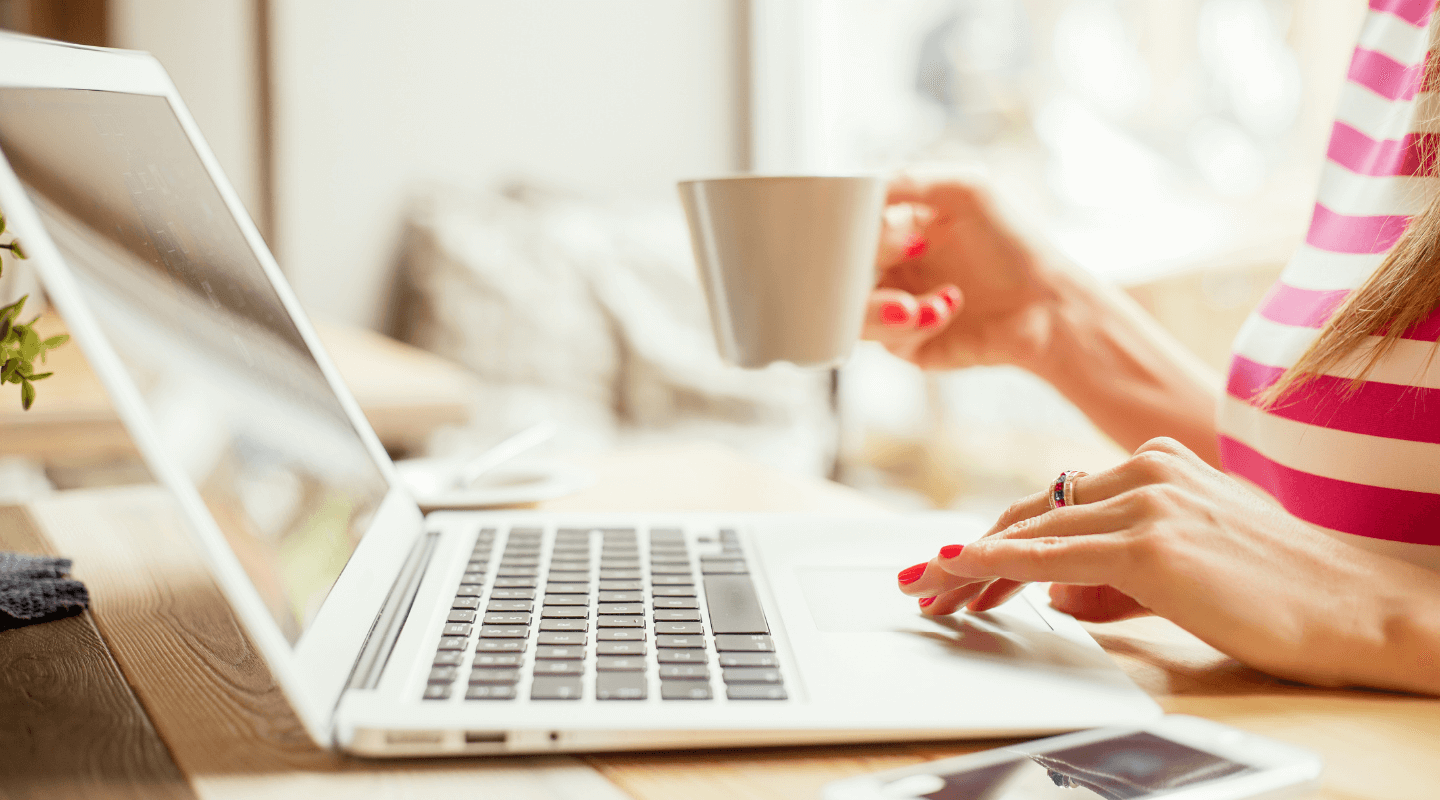 Žena sa šalicom kave na laptopu