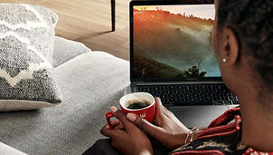 Djevojka pije Nescafé kavu pored laptopa